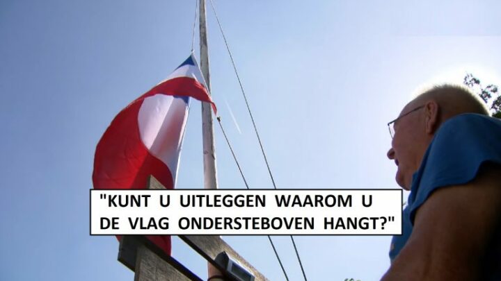 Hilarische beelden: Onwetende man legt uit waarom hij vlag ondersteboven hangt!
